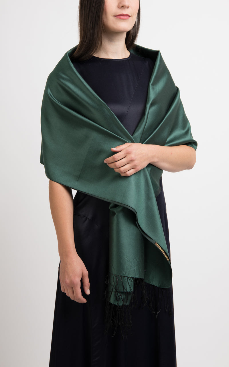 model wearing a reversible silk wrap pashmina shawl in plain forest green and dark green, made out of pure silk from The Little Tibet