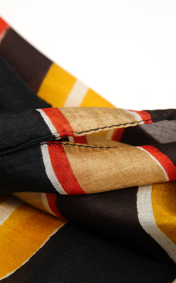 Close up of stripey patterned silk scarf with yellow beige and black  accents