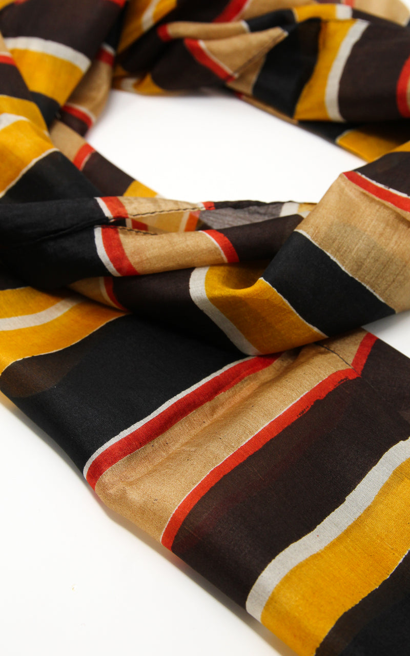 Close up of black, yellow and red stripey patterned 100% silk scarf 