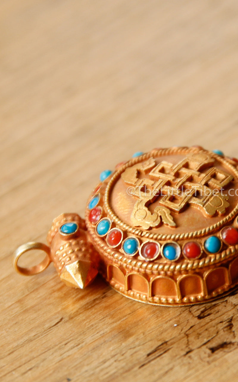 circular Gold Plated Endless Knot auspicious symbol Locket ruby emerald stones close up