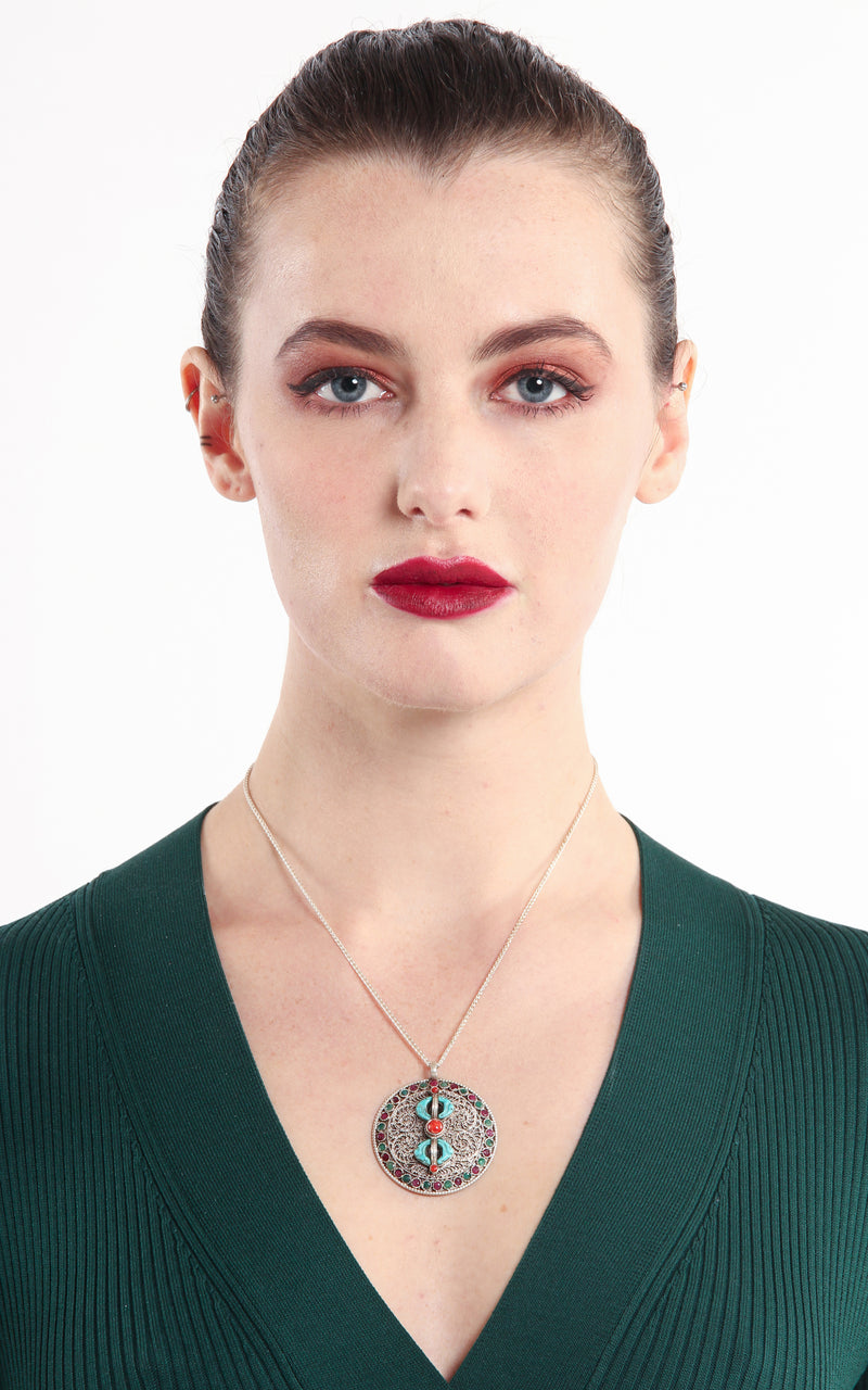 model wearing Silver Dorjee Pendant turquoise coral ruby emerald embellishment