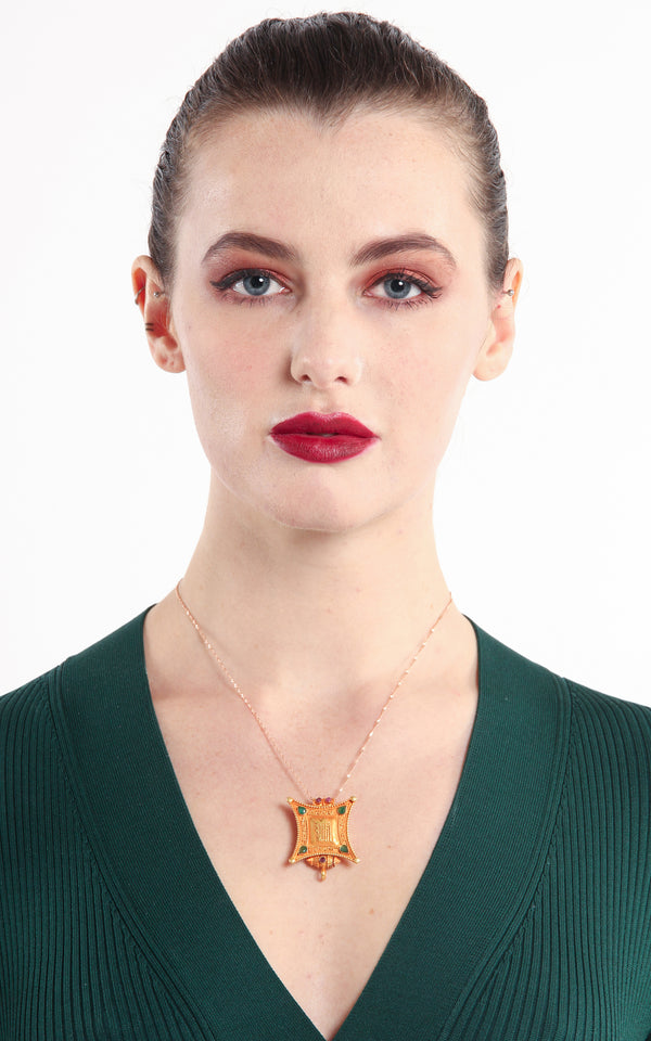 model wearing Gold Kalachakra Wheel of Time Locket Pendant ruby emerald accents