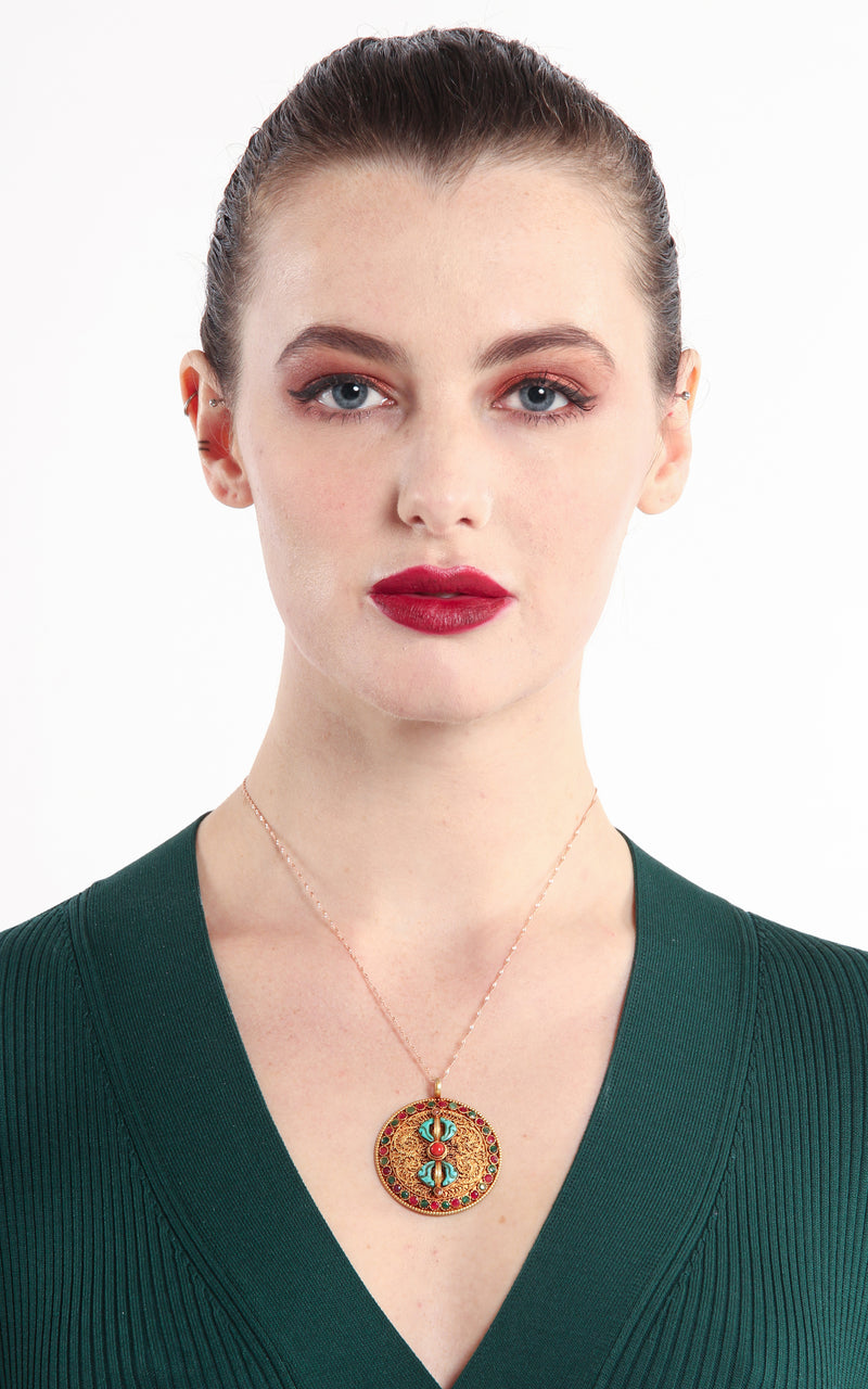 model wearing Circular Gold Dorjee Pendant turquoise coral ruby emerald accents