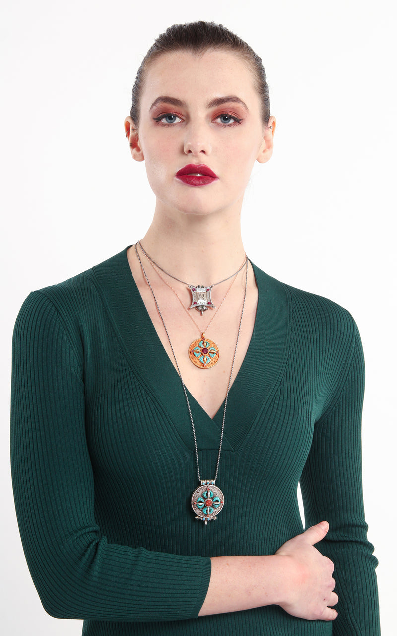 model wearing circular Gold Om Locket Pendant turquoise coral detail